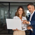 Man and woman discussing project on laptop